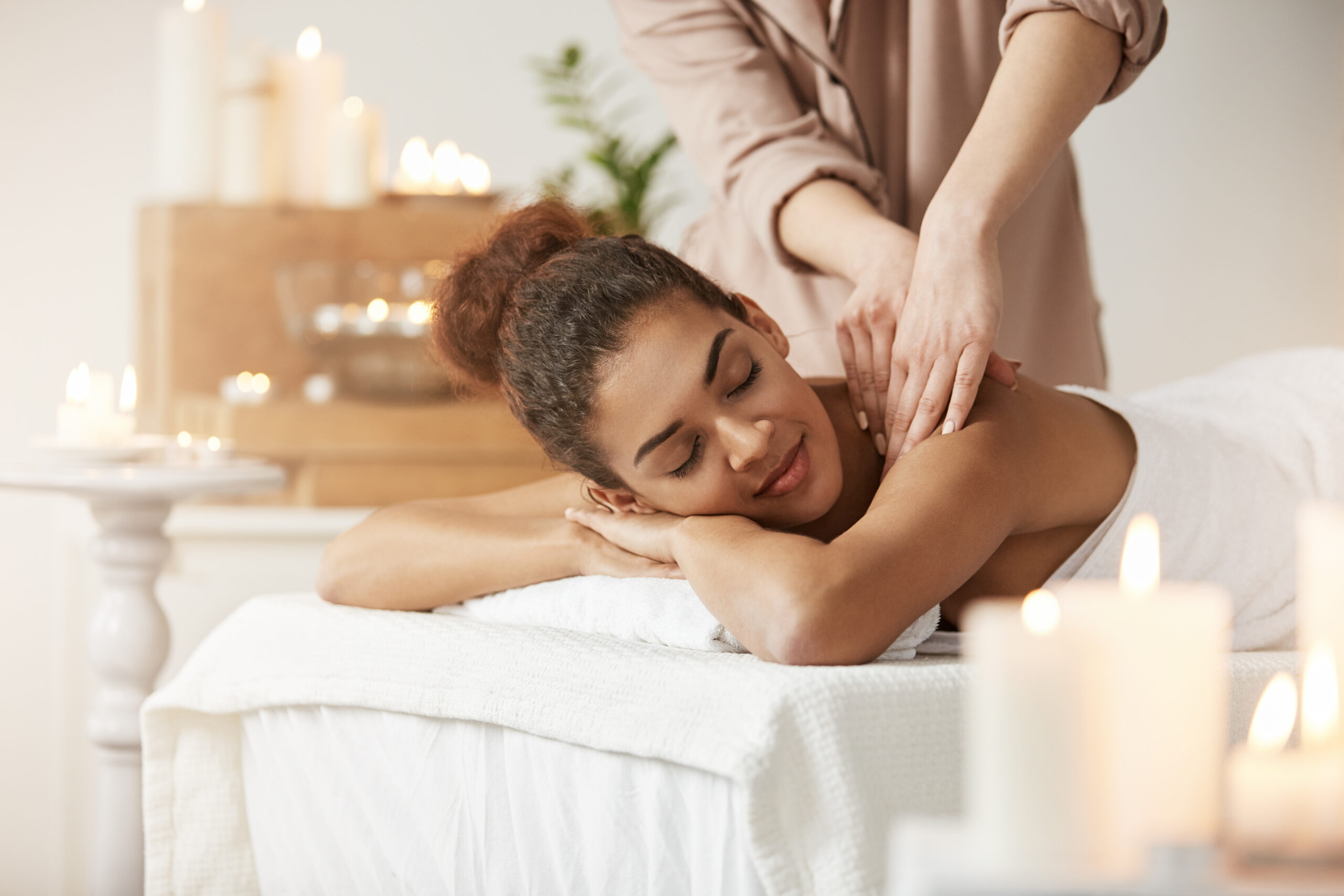 tender-african-woman-smiling-enjoying-massage-with-closed-eyes-in-spa-resort-scaled-1.jpg