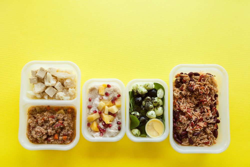 recipientes-de-plastico-com-comida-deliciosa-sobre-superficie-amarela.jpg